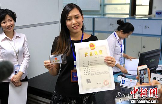 资料图：公司人员展示其领取的营业执照。中新社发 钟欣 摄